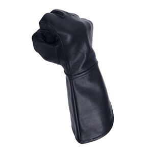 Op de afbeelding: Een zwarte leren handschoen met een lange manchet, gebald tot een vuist.