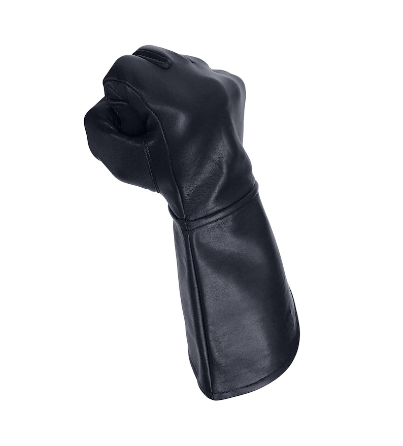 Op de afbeelding: Een zwarte leren handschoen met een lange manchet, gebald tot een vuist.