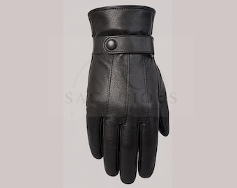 May include: A black leather glove featuring a wrist strap with a single snap button closure. The glove has visible vertical stitching along the back of the hand and fingers, with a smooth texture and a structured cuff design for a secure fit.