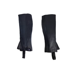 Könnte beinhalten: Ein Paar schwarze Reitstiefel aus Leder mit einem Reißverschluss an der Seite und einem Riemen am Knöchel.