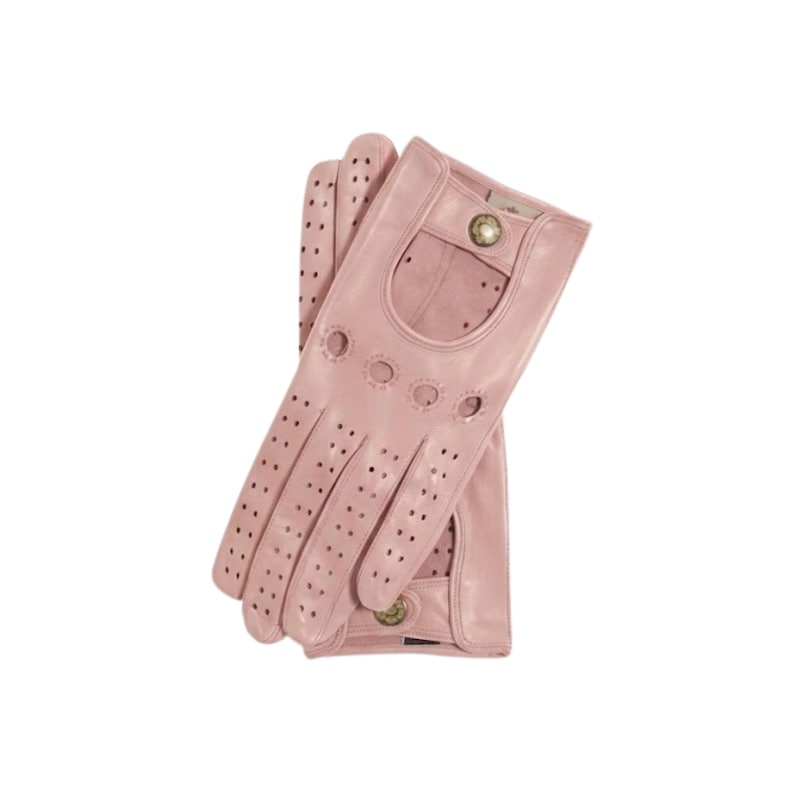 May include: A pair of dusty pink leather driving gloves featuring perforated detailing along the fingers and back of the hand. The gloves include a cutout design at the wrist with a metallic snap button closure and additional ventilation holes.