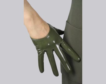 May include: A short, olive green glove with a glossy, smooth finish. The glove features a rounded wrist opening and covers the fingers and palm, leaving the wrist exposed. The material appears to have a slight sheen, reflecting light across its surface.