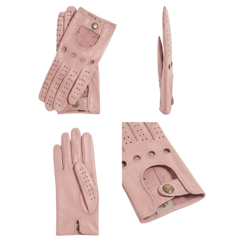 May include: A pair of light pink leather driving gloves featuring perforated detailing on the fingers and knuckles, a cutout on the back of the hand, and a small metallic snap button closure at the wrist for a secure fit and ventilation.