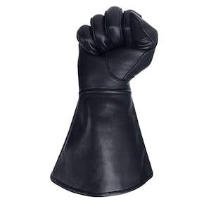 Op de afbeelding: Een zwarte leren handschoen met een lange manchet, de hand is gebald tot een vuist.