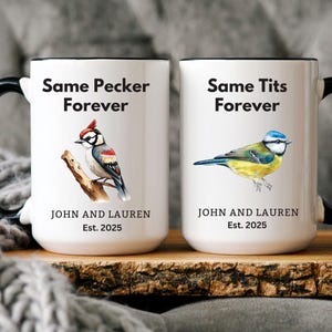 Set of two white ceramic mugs with black handles featuring humorous bird-themed designs. One mug has a woodpecker with the phrase 'Same Pecker Forever,' and the other has a blue tit with 'Same Tits Forever.' Personalized with names and 'Est. 2025.'