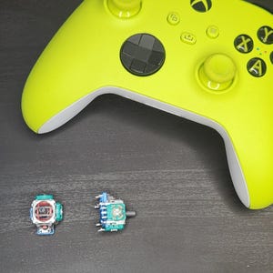 May include: A bright green Xbox controller with two replacement thumbsticks. One thumbstick is blue and green, and the other is red and black.