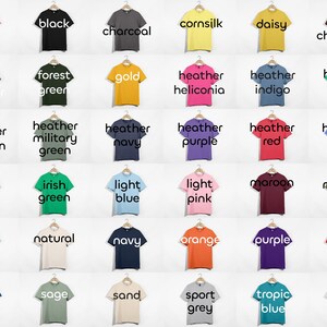 May include: A chart of 36 different colored t-shirts, each with a different color name printed on the front. The colors include azalea, black, charcoal, cornsilk, daisy, dark chocolate, dark heather, forest green, gold, heather heliconia, heather indigo, heather irish green, heather maroon, heather military green, heather navy, heather purple, heather red, heather royal, ice grey, irish green, light blue, light pink, maroon, military green, mint green, natural, navy, orange, purple, red, royal, sage, sand, sport grey, tropic blue, and white.