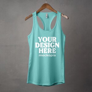 K&ouml;nnte beinhalten: Ein t&uuml;rkisfarbenes Tanktop mit einem wei&szlig;en Racerback-Design. Das Tanktop hat den Text "YOUR DESIGN HERE" und "mockopia" auf der Vorderseite.