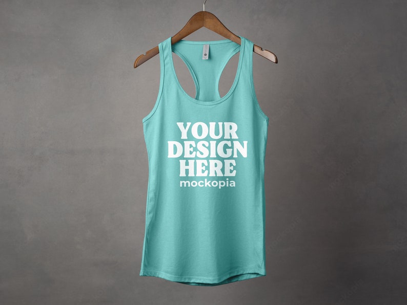 K&ouml;nnte beinhalten: Ein t&uuml;rkisfarbenes Tanktop mit einem wei&szlig;en Racerback-Design. Das Tanktop hat den Text "YOUR DESIGN HERE" und "mockopia" auf der Vorderseite.
