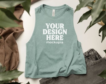 May include: A teal blue sleeveless tank top with the text "YOUR DESIGN HERE mockopia" printed in white on the front.