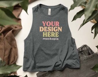 May include: A dark gray sleeveless tank top with the text "YOUR DESIGN HERE mockopia" printed in colorful letters.