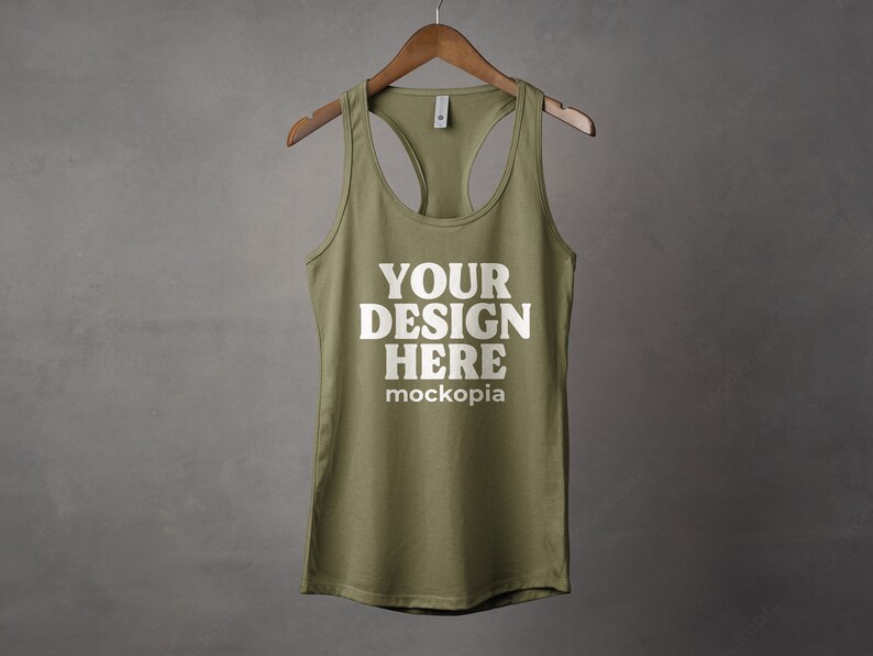 K&ouml;nnte beinhalten: Ein gr&uuml;nes Tanktop mit einem wei&szlig;en Racerback-Design. Das Tanktop hat den Text "YOUR DESIGN HERE" und "mockopia" auf der Vorderseite.