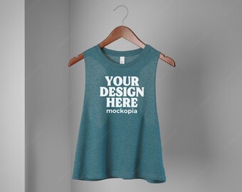 May include: A teal blue sleeveless tank top with the text "YOUR DESIGN HERE" and "mockopia" printed on the front.