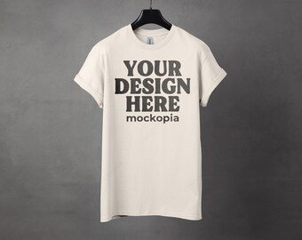 May include: A white t-shirt with the text "YOUR DESIGN HERE" and "mockopia" printed on the front.