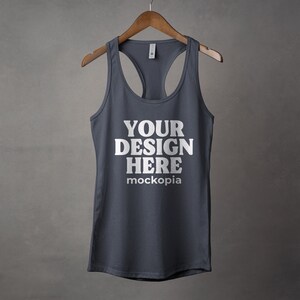 K&ouml;nnte beinhalten: Ein dunkelgraues Tanktop mit Racerback-Design. Das Tanktop hat den Text "YOUR DESIGN HERE" und "mockopia" auf der Vorderseite aufgedruckt.