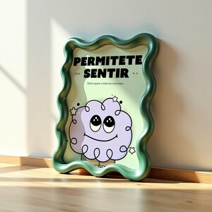 May include: A framed art print with a whimsical design. The print features a smiling purple cloud with large eyes and stars, set against a light green background. The frame is a wavy, sage green color, and the text "PERMITETE SENTIR" is displayed at the top.
