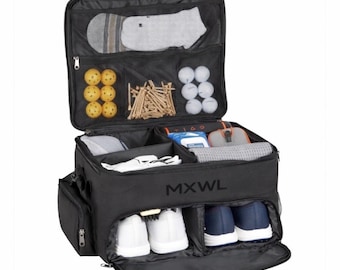 May include: A black golf locker bag with the text MXWL printed on the front. The bag is open, revealing multiple compartments containing yellow and white golf balls, wooden tees, a pair of white shoes, a pair of blue shoes, and various accessories.