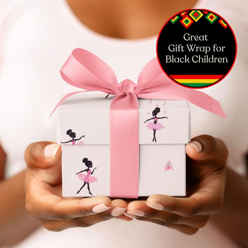 May include: A white gift box wrapped with a pink ribbon and bow. The box is decorated with illustrations of a ballerina in a pink tutu. A circular graphic reads "Great Gift Wrap for Black Children."
