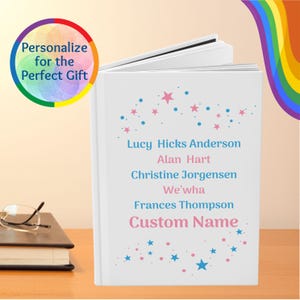 May include: A white personalized journal with blue and pink stars. The cover includes the text "Personalize for the Perfect Gift" and several names, including "Custom Name."