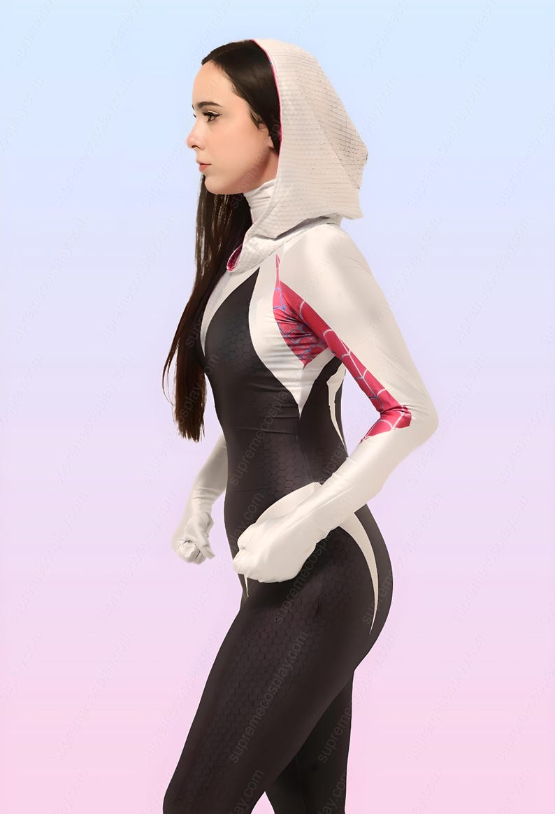 Puede incluir: Una mujer con un traje de spandex blanco y negro con una chaqueta con capucha blanca. El traje tiene un dise&ntilde;o de telara&ntilde;a en los brazos y el pecho. La mujer est&aacute; de pie con los brazos a los lados y la cabeza girada hacia un lado.