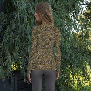 May include: A long-sleeved shirt with a geometric pattern in shades of brown and gold. The shirt has a high neckline and a fitted silhouette.