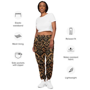 May include: Black and gold patterned sweatpants with an elastic waistband, side pockets with zippers, and a relaxed fit. The sweatpants are lightweight and water-resistant.