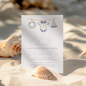 May include: A baby shower invitation with a nautical theme. The invitation features watercolor illustrations of a life preserver, onesie, and sailboat. The text reads "Ahoy, It's a Boy" and includes event details.