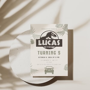 Puede incluir: Una invitaci&oacute;n de cumplea&ntilde;os beige con tem&aacute;tica de dinosaurios. La invitaci&oacute;n presenta el nombre "LUCAS", las palabras "TURNING 5" y los detalles del evento. Tambi&eacute;n se incluye una silueta de un jeep y un dinosaurio.