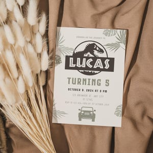 Puede incluir: Una invitaci&oacute;n de cumplea&ntilde;os con tem&aacute;tica de dinosaurios. La invitaci&oacute;n presenta el nombre "LUCAS" y el texto "TURNING 5". La fecha es el 9 de octubre de 2024 a las 15:00. La invitaci&oacute;n incluye un gr&aacute;fico de jeep y hojas decorativas.