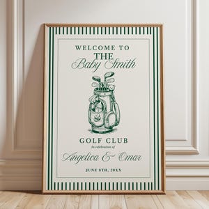 Può includere: Una stampa incorniciata a tema golf. Il testo recita "Benvenuti al Baby Smith Golf Club" con i nomi Angelica & Omar e la data 8 giugno 20XX. L'opera presenta una sacca da golf con mazze in uno schema di colori verde e bianco.