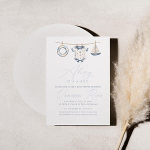 May include: A baby shower invitation with a nautical theme. The invitation features watercolor illustrations of a life preserver, a onesie, and a sailboat. The text reads "Ahoy, It's a Boy" and includes event details.