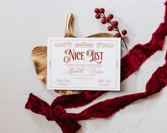 May include: A festive "Nice List" certificate with ornate gold detailing and burgundy text. The certificate, personalized with a name, is set against a white background with a gold leaf and red ribbon. A sprig of red berries adds a holiday touch.