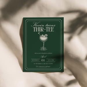 K&ouml;nnte beinhalten: Dunkelgr&uuml;ne Einladungskarte mit wei&szlig;em Text und einer Golf-Illustration. Der Text lautet "Kevin turns THIR-TEE" und enth&auml;lt Eventdetails: 01. April, 19 Uhr und eine Adresse. Das Kartendesign zeigt einen Golfball-Cocktail.
