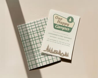 Invitation pour le premier anniversaire d'un garçon sur le thème du camping : thème « Un campeur heureux », aventure rustique en plein air, modèle Canva modifiable et téléchargeable.