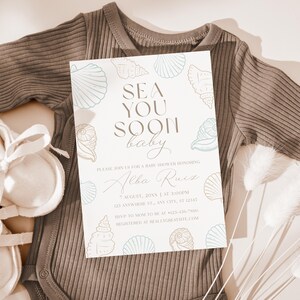 Może przedstawiać: Zaproszenie na baby shower z napisem "SEA YOU SOON baby" i ilustracjami muszli. Zaproszenie znajduje się na białym tle i jest otoczone szarym body i bucikami dla dziecka. Zaproszenie zawiera imię Alba Ruiz i szczeg&oacute;ły wydarzenia.