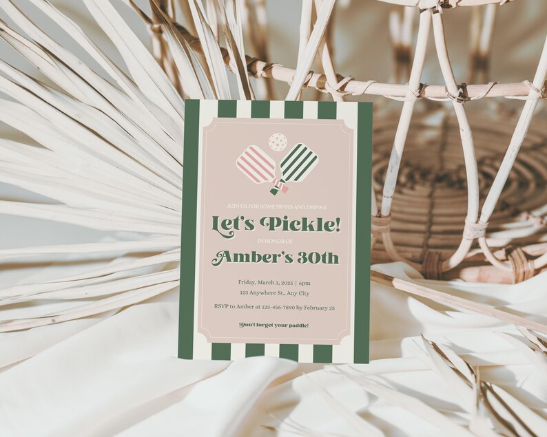 May include: A green and white striped invitation card with a pink and green pickleball paddle illustration. The text on the card reads "Let's Pickle! Amber's 30th" and includes details for a party on Friday, March 3rd at 123 Anywhere St., Any City. The RSVP information is also included.
