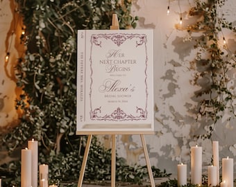 May include: A bridal shower welcome sign on an easel. The sign is white with burgundy text and decorative borders. The text reads "Her Next Chapter Begins" and welcomes guests to Alexa's bridal shower on March 14, 20XX. The words "The Future Mrs. Morales" are on the side.