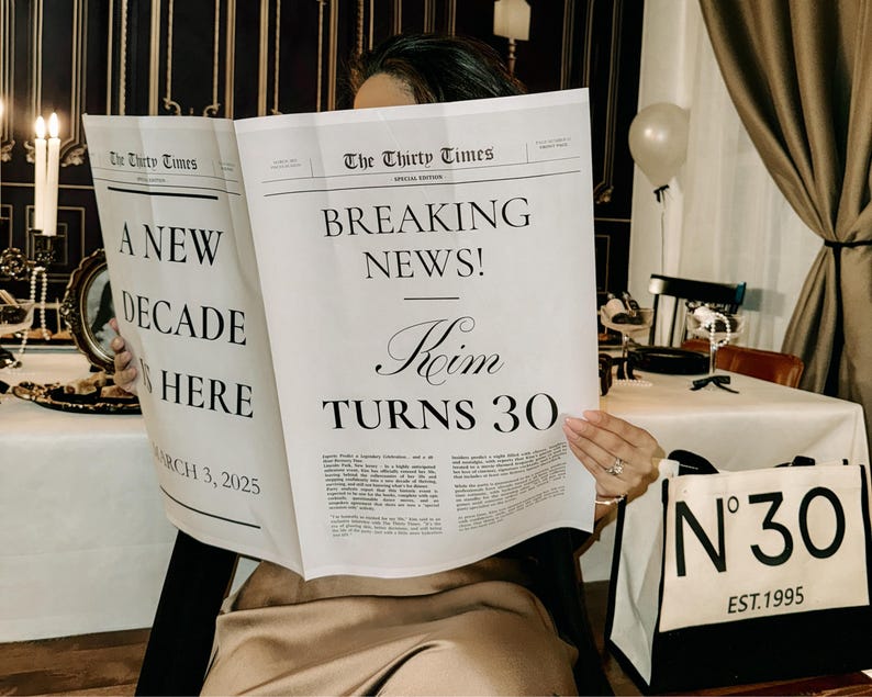 K&ouml;nnte beinhalten: Eine Frau h&auml;lt eine Zeitung mit der Schlagzeile "Breaking News! Roim Turns 30" und dem Text "A New Decade is Here" auf der linken Seite. Sie h&auml;lt eine wei&szlig;e Tragetasche mit schwarzem Besatz und dem Text "N&deg;30 EST. 1995" auf der Vorderseite.