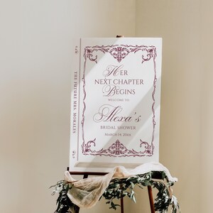 Puede incluir: Un letrero blanco sobre un caballete con texto burdeos y bordes decorativos. El letrero dice "Her Next Chapter Begins" y da la bienvenida a los invitados a la despedida de soltera de Alexa el 14 de marzo de 20xx. El texto "The Future Mrs. Morales" est&aacute; impreso verticalmente en el lateral.