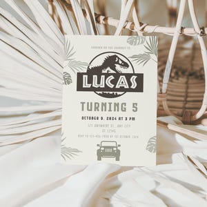 Puede incluir: Una invitaci&oacute;n de cumplea&ntilde;os beige claro con tem&aacute;tica de dinosaurios. La invitaci&oacute;n dice "LUCAS TURNING 5" con la fecha y hora de la fiesta. Tambi&eacute;n se incluye una silueta de dinosaurio y un gr&aacute;fico de jeep.