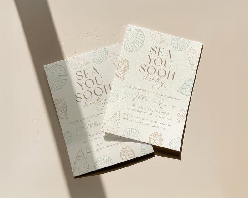 Może przedstawiać: Dwa zaproszenia na baby shower z motywem muszli. Zaproszenia są w kolorze jasnobeżowym ze słowami "Sea You Soon baby" w czcionce skryptowej. Zaproszenia zawierają r&oacute;wnież imię "Alba Ruiz" i szczeg&oacute;ły wydarzenia.