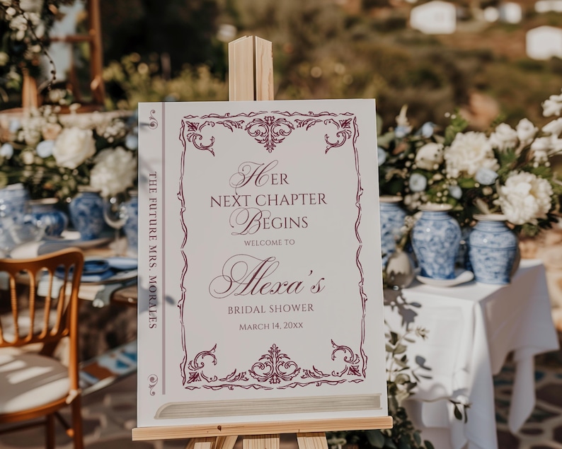 Puede incluir: Un letrero blanco sobre un caballete con el texto "Her Next Chapter Begins" en escritura burdeos, dando la bienvenida a los invitados a la despedida de soltera de Alexa. El letrero est&aacute; decorado con bordes ornamentados y la fecha 14 de marzo de 20xx. Las palabras "The Future Mrs. Morales" est&aacute;n impresas verticalmente en el lateral.
