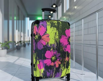 May include: A rolling suitcase with a floral design. The suitcase features large pink and purple flowers against a black and lime green background. The luggage has a retractable handle and four wheels.