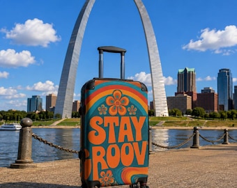 May include: A rolling suitcase with a teal, orange, and yellow retro-inspired graphic print featuring the text "STAY GROOVY" and stylized flower motifs. The luggage has a retractable silver handle and four black wheels, standing upright.