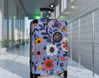 May include: A blue suitcase with a floral pattern featuring colorful flowers and leaves. The suitcase has a black handle and wheels.