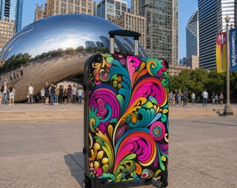May include: A hard-shell rolling suitcase featuring a vibrant, multi-colored swirling pattern in shades of hot pink, bright yellow, teal, and orange against a black background, equipped with a retractable silver handle and four black spinner wheels.