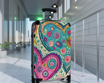 May include: A colorful suitcase with a paisley pattern and hearts. The suitcase is on wheels and has a retractable handle.