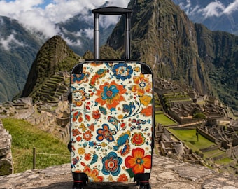 May include: A rolling suitcase featuring a cream-colored background with a vibrant, multi-colored floral and paisley pattern in shades of orange, blue, yellow, and green. The luggage has a black frame, a retractable handle, and four wheels.