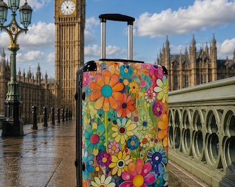 May include: A rolling suitcase featuring a vibrant, multi-colored floral pattern with large orange, yellow, pink, and blue daisy-like flowers. The luggage has a black frame, a retractable silver handle, and four black wheels for mobility.