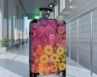 May include: A floral patterned suitcase with pink, yellow, and orange flowers. The suitcase has a black handle and wheels.